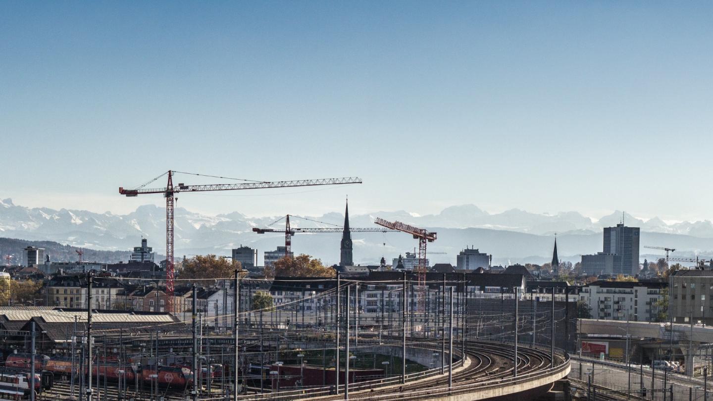 vue d'une ville en travaux , voie de train, grues 